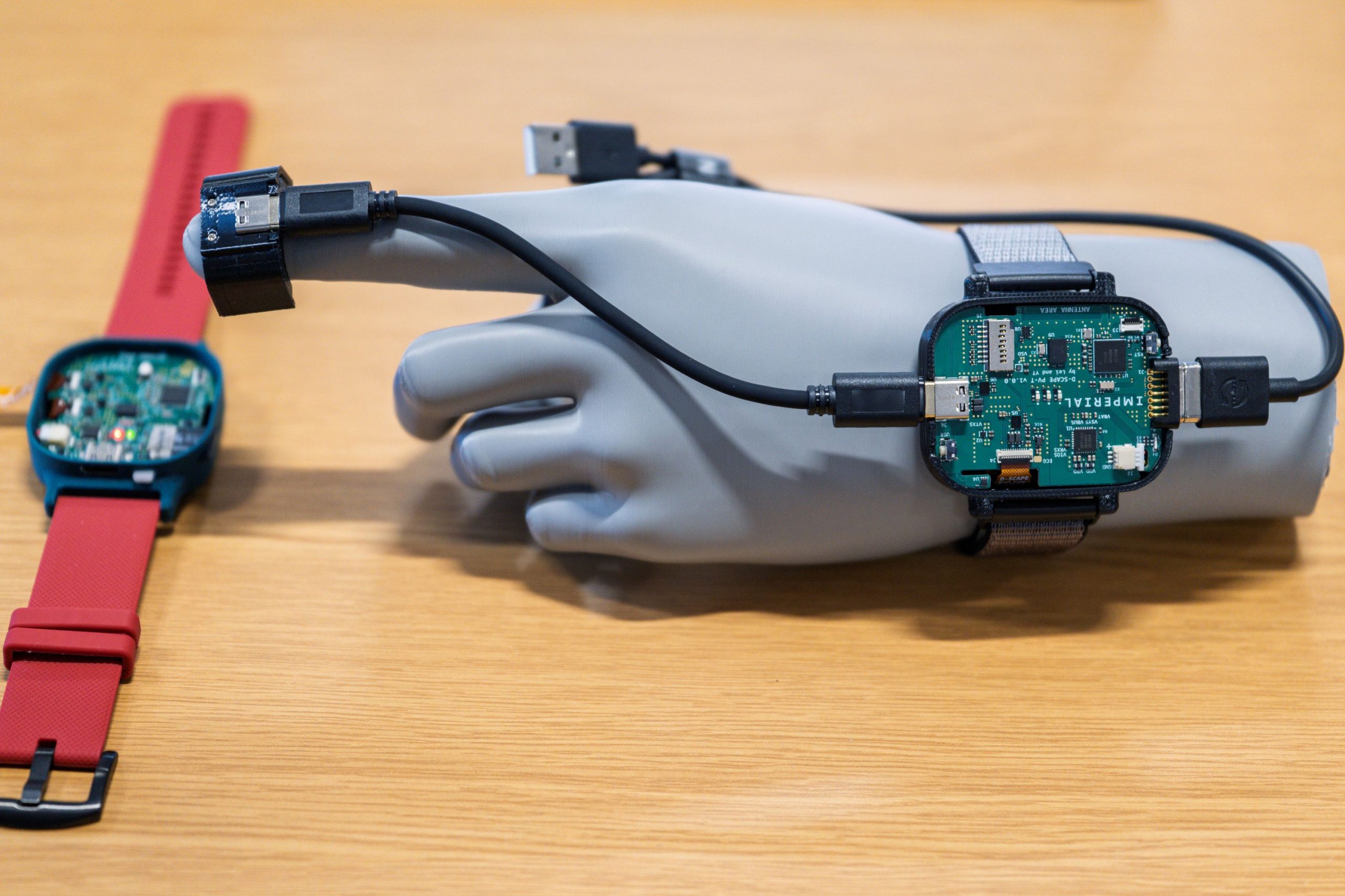 a model hand with a v3 prototype device worn on the wrist with an attached finger probe