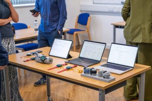 Two laptops, a tablet and a mobile sitting on a desk with a selection of D-SCAPE devices